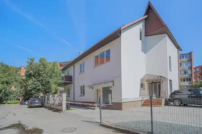 a white house with a fence in front of it at Green Apartment with free parking in Kaunas