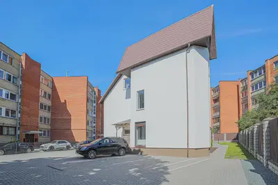 a car parked in front of a white building at Green Apartment with free parking in Kaunas