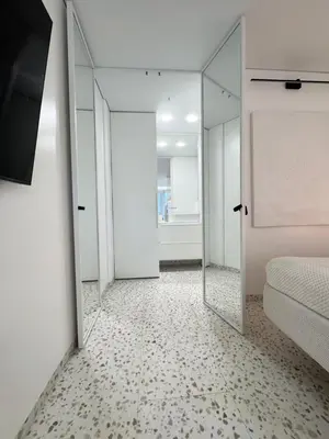 a room with a mirror and a bed and a bedroom at Bright white in Vilnius