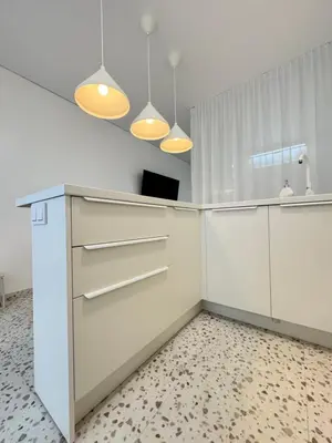 a white kitchen with white cabinets and lights at Bright white in Vilnius