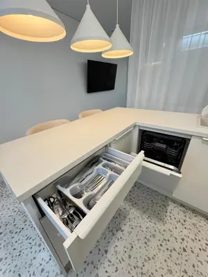 a kitchen with a white counter with an open drawer at Bright white in Vilnius