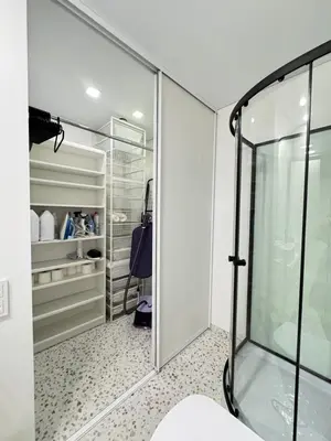 a walk in closet with a glass shower stall at Bright white in Vilnius