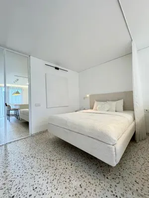 a white bedroom with a large bed and a table at Bright white in Vilnius