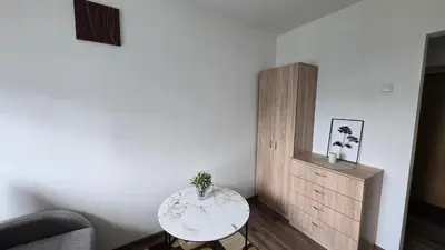a living room with a table and a cabinet at Virš miesto in Utena