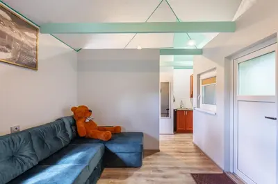 a teddy bear sitting on a couch in a living room at Baba Yaga Treehouse in Meškiai