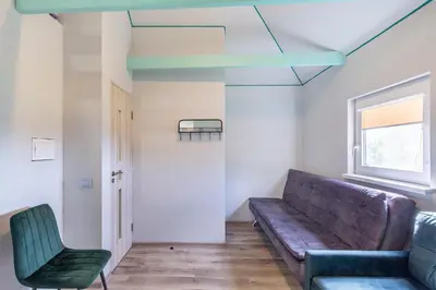 a living room with a couch and a chair at Baba Yaga Treehouse in Meškiai