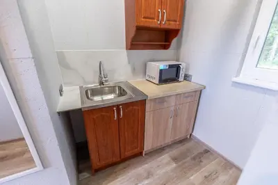 a small kitchen with a sink and a microwave at Baba Yaga Treehouse in Meškiai