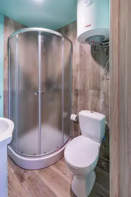 a bathroom with a shower with a toilet and a sink at Baba Yaga Treehouse in Meškiai