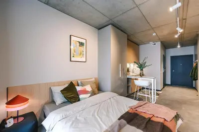 a bedroom with a bed and a desk in it at Liv in Vilnius New town in Vilnius