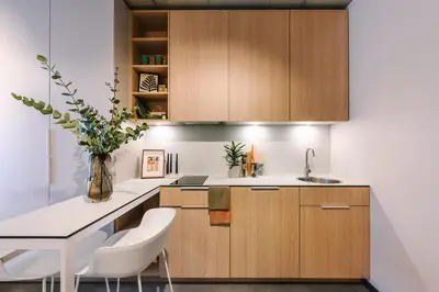 a kitchen with wooden cabinets and a table and chairs at Liv in Vilnius New town in Vilnius