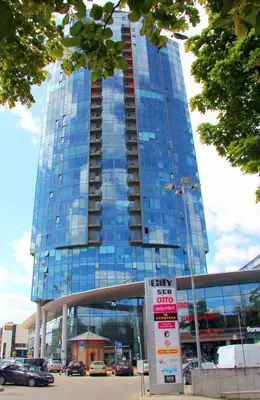 a large glass building with a sign in front of it at Helios 19 Luxury Vilnius Apartment in Vilnius