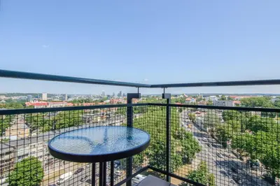 a balcony with a table and a view of the city at Helios 19 Luxury Vilnius Apartment in Vilnius