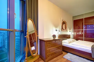 a bedroom with a bed and a dresser and a mirror at Helios 19 Luxury Vilnius Apartment in Vilnius