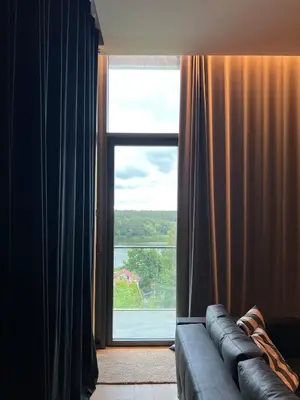 a living room with a couch and a large window at Design apartment with view to Nemunas, Prienai in Pakopi