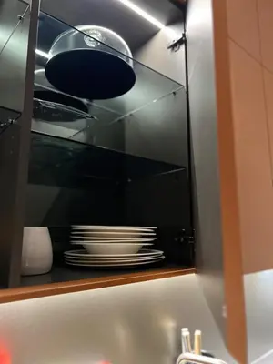 a cabinet with a stack of plates in it at Design apartment with view to Nemunas, Prienai in Pakopi