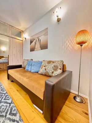 a living room with a couch and a lamp at Old Town T8 SELF Check In in Vilnius