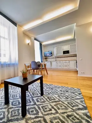 a living room with a coffee table and a kitchen at Old Town T8 SELF Check In in Vilnius