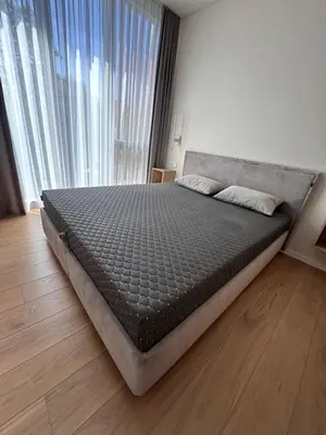 a bed in a bedroom with a large window at Apartamentai prie Soboro in Kaunas