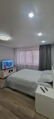 a bedroom with a bed and a flat screen tv at Apartamentai Grigiškes in Grigiškės