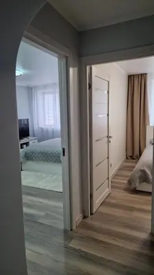 a room with a bedroom with a bed and a mirror at Apartamentai Grigiškes in Grigiškės