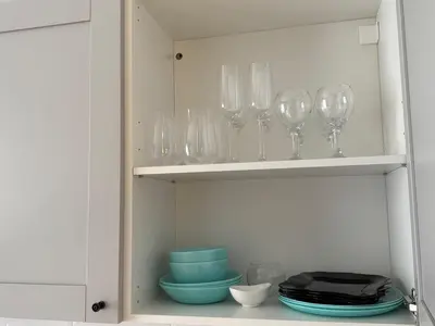 a cupboard filled with wine glasses and bowls at Maironio g Centras in Kaunas