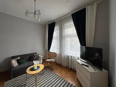 a living room with a couch and a television at Maironio g Centras in Kaunas