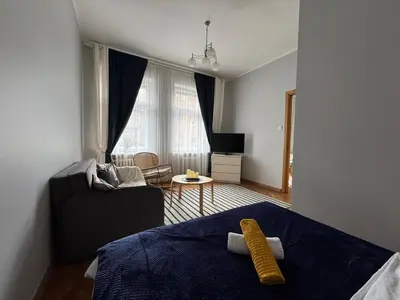 a bedroom with a bed and a living room at Maironio g Centras in Kaunas