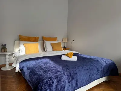 a bedroom with a large bed with a blue blanket at Maironio g Centras in Kaunas