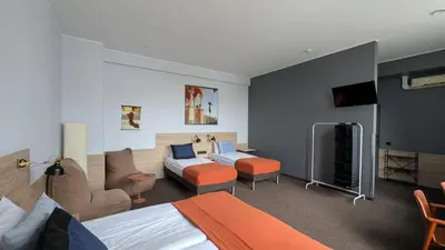 a hotel room with two beds and a tv at Stylish Private Room in Art Hotel Central Vilnius in Vilnius