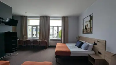 a hotel room with a bed and a table at Stylish Private Room in Art Hotel Central Vilnius in Vilnius