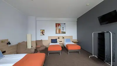 a bedroom with a bed and a living room with a couch at Stylish Private Room in Art Hotel Central Vilnius in Vilnius