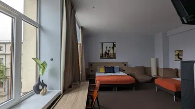 a bedroom with a bed and a couch in a room at Stylish Private Room in Art Hotel Central Vilnius in Vilnius