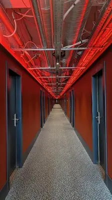 an empty corridor with red walls and doors at Stylish Private Room in Art Hotel Central Vilnius in Vilnius