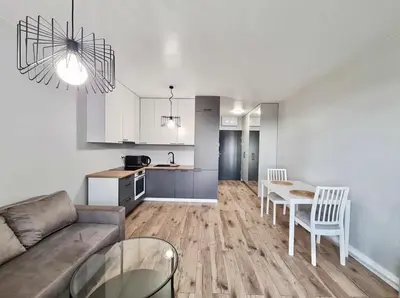 a living room and kitchen with a couch and a table at Krivių Street Residential in Vilnius