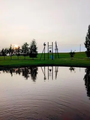 a park with a reflection in a body of water at Atokvėpis Alantos kaime in Alanta