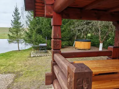 a wooden bench on the porch of a cabin at Atokvėpis Alantos kaime in Alanta