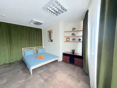 a bedroom with a blue bed and green curtains at Seliu 29 in Vilnius