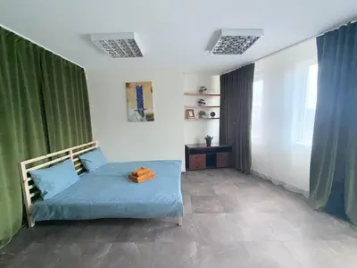 a bedroom with a blue bed and green curtains at Seliu 29 in Vilnius