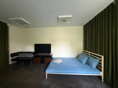 a bedroom with a blue bed and a television at Seliu 29 in Vilnius