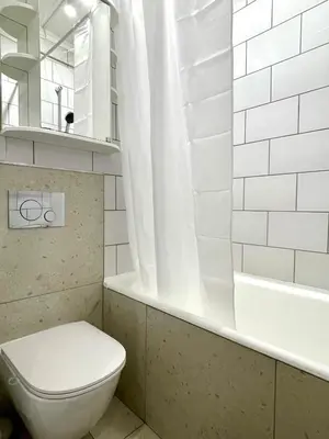 a white bathroom with a toilet and a bath tub at Mens Cave in Šiauliai