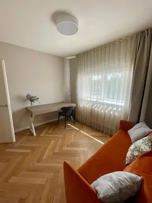 a room with a couch and a desk and a window at Cashmere apartment in Žaliakalnis in Kaunas