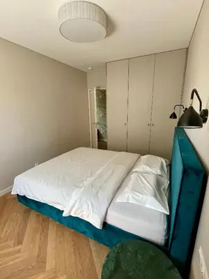a bedroom with a large bed with a blue frame at Cashmere apartment in Žaliakalnis in Kaunas