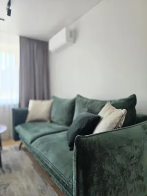 a green couch with pillows on it in a living room at Central Stay in Šiauliai in Šiauliai
