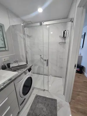 a bathroom with a shower and a washing machine at Central Stay in Šiauliai in Šiauliai