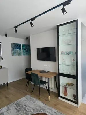 a dining room with a table and a tv at Central Stay in Šiauliai in Šiauliai
