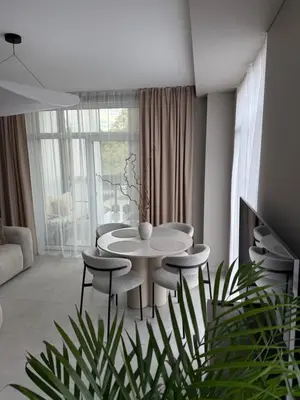 a living room with a white table and chairs at Moonlight Apartment - Parko rezidencija SELF CHECK IN in Panevėžys