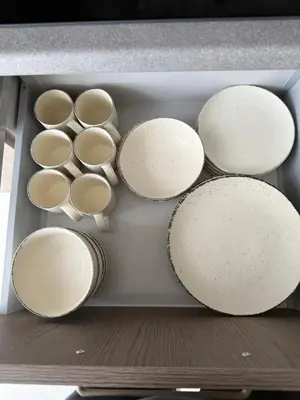 a drawer full of white plates in a refrigerator at Moonlight Apartment - Parko rezidencija SELF CHECK IN in Panevėžys