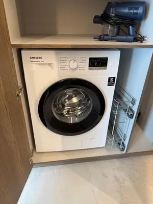 a white washing machine sitting in a cabinet at Moonlight Apartment - Parko rezidencija SELF CHECK IN in Panevėžys