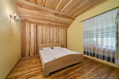 a bedroom with a bed with a wooden ceiling at Poilsio kompleksas Tolieja Vieta renginiams bei poilsiui ant ežero kranto in Kulionys