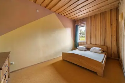a bedroom with a bed with two towels on it at Poilsio kompleksas Tolieja Vieta renginiams bei poilsiui ant ežero kranto in Kulionys